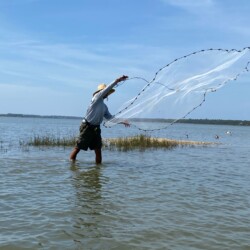 Indian Pass Cary in the marsh throwing his cast net for bait